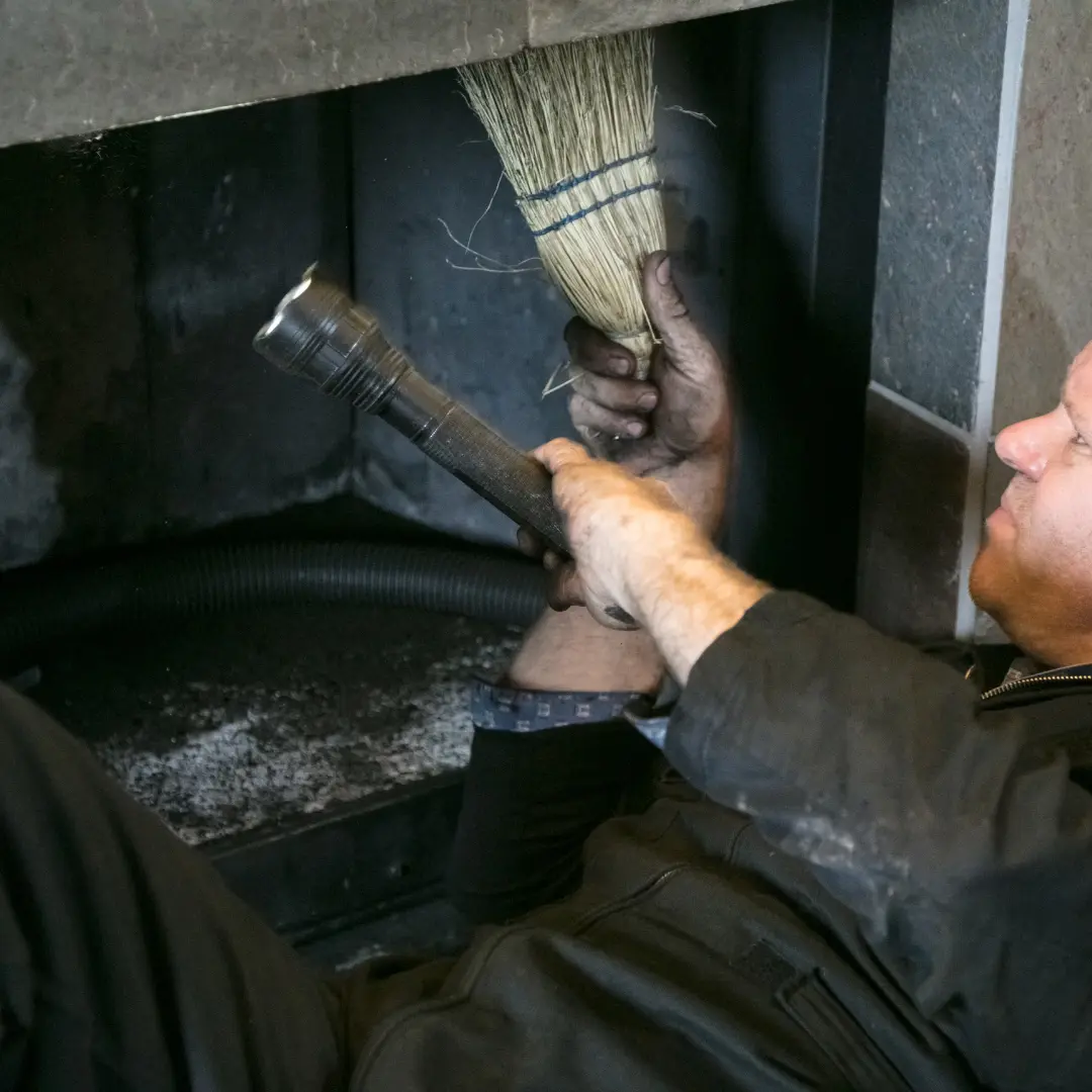 Man conducting wooden fireplace clean